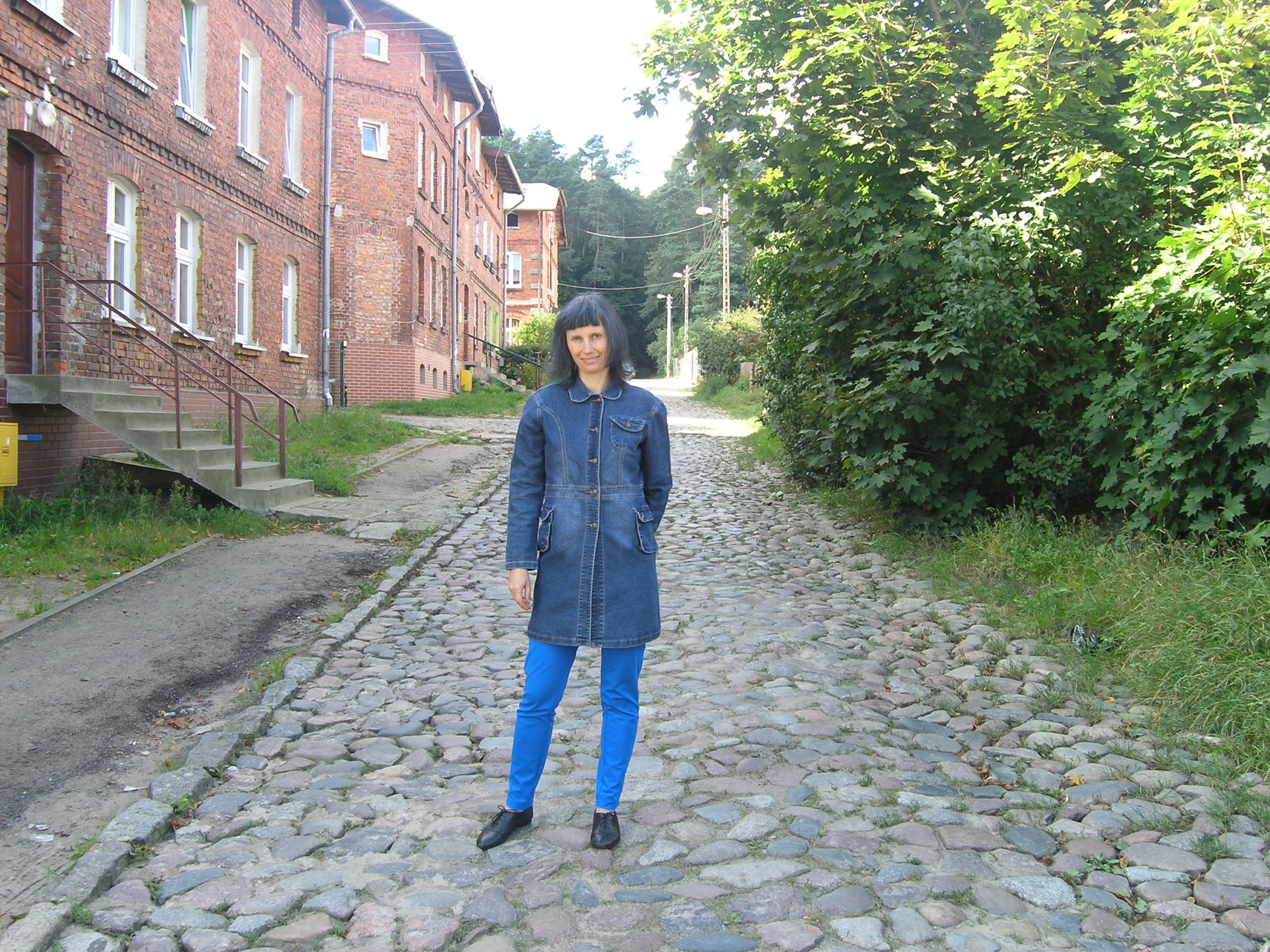 Violetta Wróblewska na tle starych ceglanych budynków