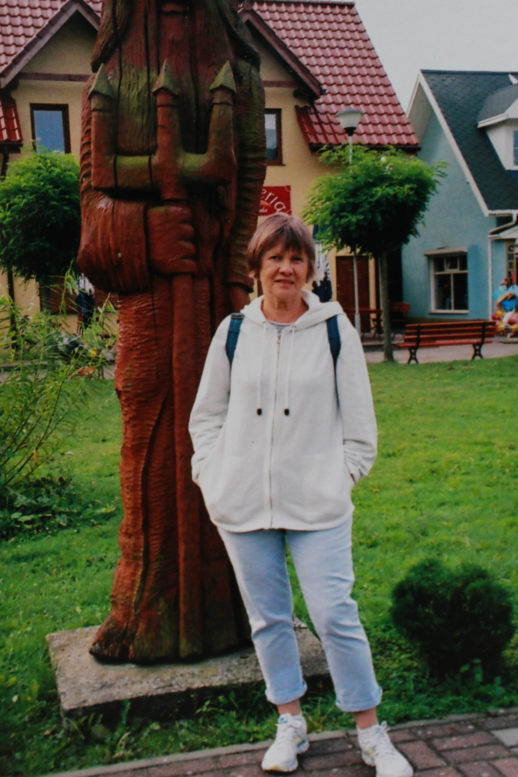 Mama na tle drewnianej rzeźby