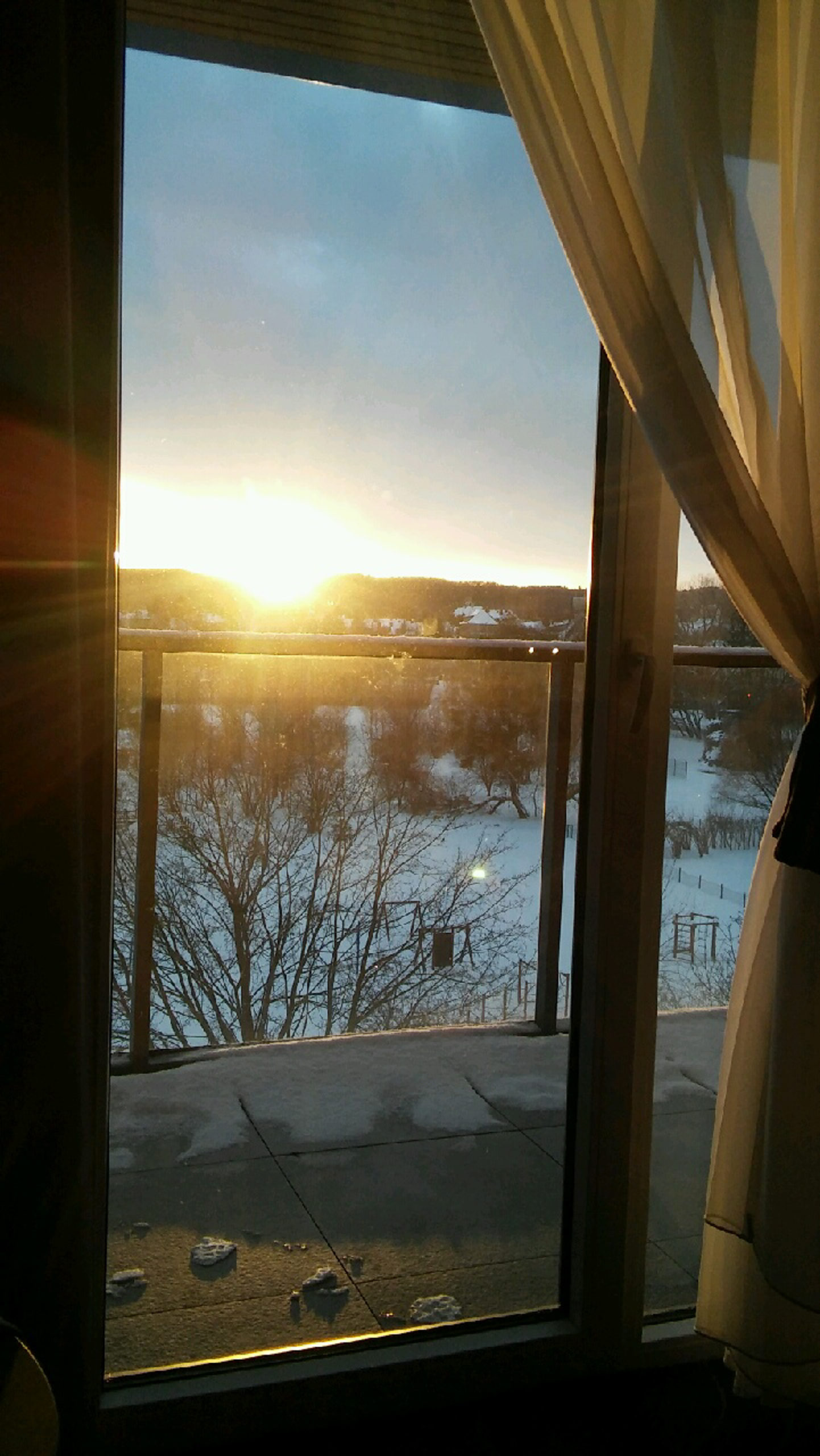 widok na zachodzące słońce z okna hotelu